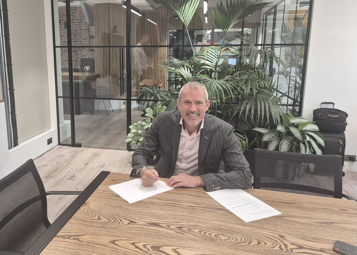 Man with pen and paper at desk in office room